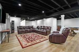 a living room with a leather couch and a chair at Buck Run - a secluded cabin in Rockbridge, OH in Rockbridge