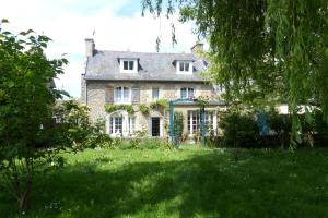a large stone house in a field of grass at Maison pour familles et amis in Dinard