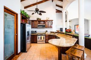 a large kitchen with a table and a ceiling fan at Private Villa, Infinity Pool, 2 Quiet Beaches in Potrero