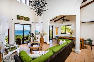 a living room with a green couch and a table at Private Villa, Infinity Pool, 2 Quiet Beaches in Potrero