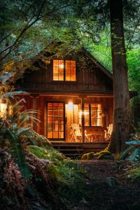 a log cabin in the woods with the lights on at Barlow Haus in Mount Hood Village +49 photos