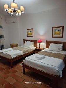 a bedroom with two beds and a chandelier at Elegant family house in Loulé with private pool in Loulé