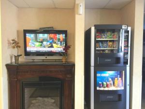 a television and a refrigerator and a fireplace with a tv at Pleasant Hill Inn in Pleasant Hill