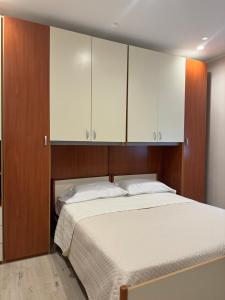una camera da letto con un letto e armadi bianchi di Casa Erminia a Caserta