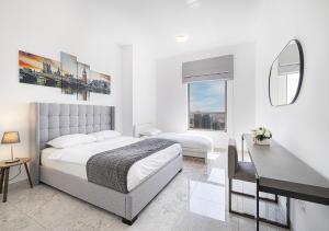 迪拜Luxury Beachfront 2Bd Apt, Shams, JBR的一间卧室，配有一张床、一张书桌和一扇窗户