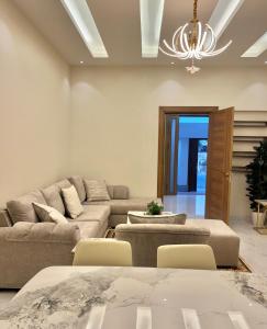 ein Wohnzimmer mit einer Couch und einem Kronleuchter in der Unterkunft شاطئ اللؤلؤ وحده مفروشه 2 in Bucht Obhor
