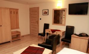 a living room with a desk and chairs and a television at Pensjonat Lido in Antonin