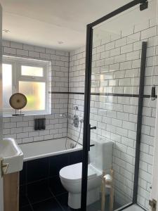 a bathroom with a toilet and a tub and a sink at 2 bedroom house in central Windsor - The Town in Windsor