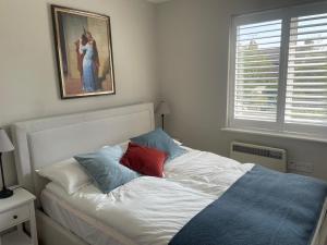 a bed in a bedroom with a painting on the wall at 2 bedroom house in central Windsor - The Town in Windsor