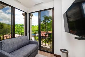 a living room with a couch and a tv at Family Villa, Pool & Exclusive Resort Access in Playa Conchal
