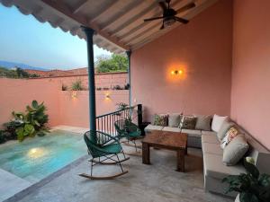 a patio with a couch and chairs and a pool at Casa la batuta in Santa Fe de Antioquia