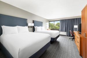 a hotel room with two beds and a desk at Courtyard Montvale in Montvale