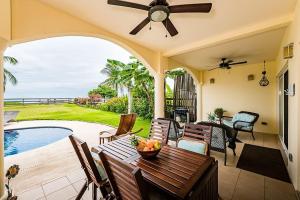 a patio with a table and chairs and a pool at Beachfront Hideaway with Pool & Ocean Views in Playa Flamingo