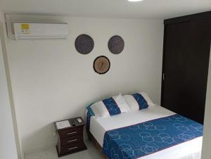 a bedroom with a bed and a wall with two mirrors at Apartamento moderno en Cali in Cali