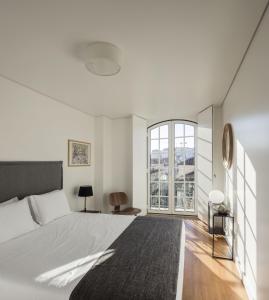 una camera da letto con un letto grande e una grande finestra di Lisbon Serviced Apartments - Baixa Castelo a Lisbona
