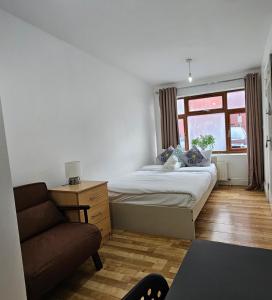 a bedroom with a bed and a couch and a window at All saints Rooms in London