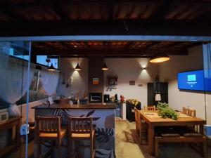 a room with a table and chairs and a kitchen at Aconchego do Pôr do Sol Sebollas in Inconfidência