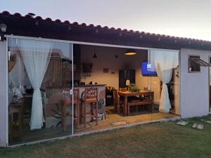 a patio with a dining table and glass doors at Aconchego do Pôr do Sol Sebollas in Inconfidência