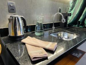 a kitchen counter with a sink and a kettle at Loft 201 em frente à Vila Germânica Oktoberfest- Villa Haus in Blumenau