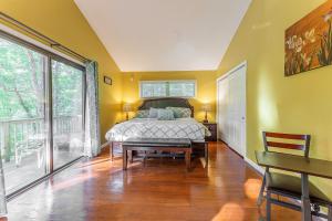 a bedroom with a bed and a table and windows at Charming Lakefront Getaway with Hot Tub & Game Room Perfect for Families! in East Stroudsburg +138 photos