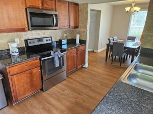 a kitchen with stainless steel appliances and a dining room at Private Villa - 3 Bedroom House in Raleigh