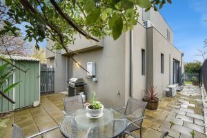 a patio with a table and chairs and a grill at Blue Chip Williamstown Beach Bay Townhouse in Williamstown