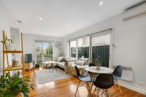 a living room with a couch and a table at Blue Chip Williamstown Beach Bay Townhouse in Williamstown