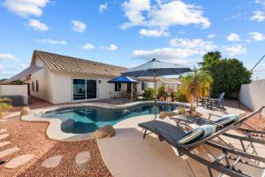 a swimming pool with chairs and an umbrella at Lavish 3br Haven W Private Pool in Mesa