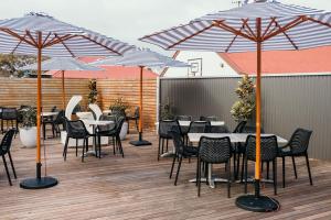 a group of tables and chairs under umbrellas on a deck at Caledonian Inn - The Stump in Port Fairy