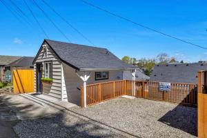 a small white house with a wooden fence at Rucker Avenue Cozy Bungalow in Everett