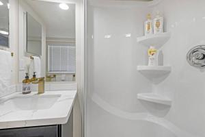 a white bathroom with a sink and a mirror at Rucker Avenue Cozy Bungalow in Everett +13 photos