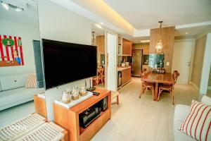 a living room with a large flat screen tv at In Mare Bali Resort Beira Mar by Qavi - 213 in Granja Beira Mar