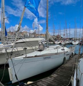 un barco blanco atracado en un muelle con otros barcos en Surfbird Cozy Sailboat Escape, en Lisboa