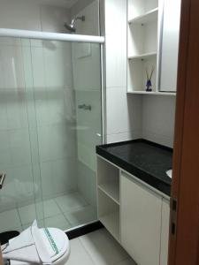 a white bathroom with a shower and a toilet at Flat térreo e condomínio aconchegante ! in Ipojuca