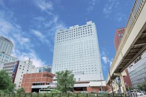 a tall white building in the middle of a city at ANA Crowne Plaza Sapporo by IHG in Sapporo