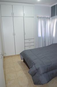 a bedroom with a bed and some white cabinets at Complejo Fátima in Villa Dolores