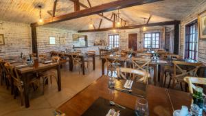 a restaurant with wooden tables and chairs in a room at Finca del Sacramento in Colonia del Sacramento