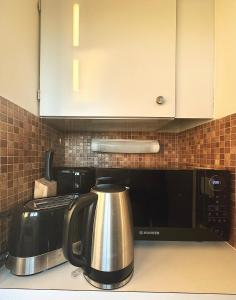 a tea kettle sitting on top of a microwave at Paris Skyview - Latin Quarter & Eiffel Tower in Paris