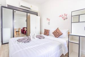 a white bedroom with two beds and a mirror at Hagone-Condotel Pattaya in Pattaya South +43 photos