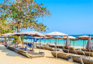 a row of umbrellas and chairs on a beach at Hagone-Condotel Pattaya in Pattaya South