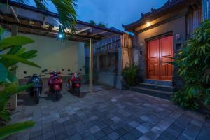 deux motos garées devant un bâtiment avec une porte rouge dans l'établissement Taman pangeran villa in Seminyak, 2BR large pool, Prime Location !, à Seminyak