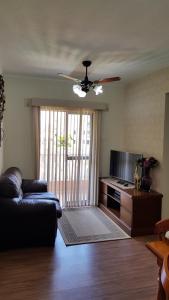 a living room with a couch and a ceiling fan at Apartamento Cabo Frio Temporada in Cabo Frio