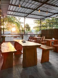 a patio with wooden tables and benches on a patio at Djembank Hotel & Restaurant in Tjakranegara