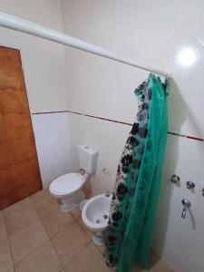 ein Badezimmer mit Toilette und Duschvorhang in der Unterkunft Los Luises - Departamentos Céntricos in Mina Clavero