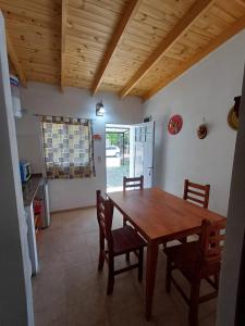 eine Küche und ein Esszimmer mit einem Holztisch und Stühlen in der Unterkunft Los Luises - Departamentos Céntricos in Mina Clavero + 24 Fotos