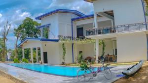 a house with two bikes parked in front of a swimming pool at Bungalow Resort - Sigiriya in Sigiriya
