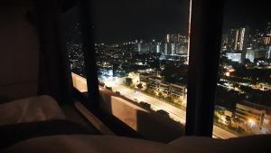a bedroom with a view of a city at night at Spectacular city view Near Georgetown 9 pax in Jelutong +9 photos