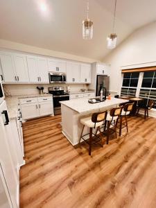a kitchen with white cabinets and a wooden floor at The Bay Stay in Shoreline Park