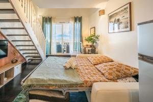 a living room with a bed and a staircase at Ti Kaz Oreo - Cosy Plage & confort - Wiskeys in Saint-Gilles les Bains