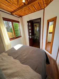 a bedroom with a bed and two windows at Recanto da Serenidade in Campos do Jordão